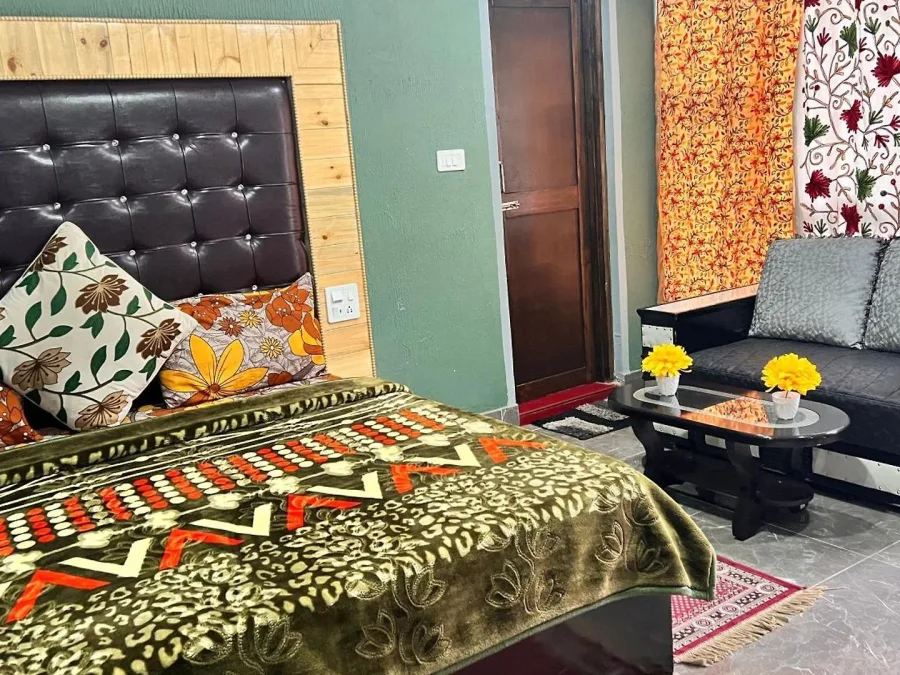 Bed and sofa in a Deluxe Room with balcony at Hotel Seven Pahalgam