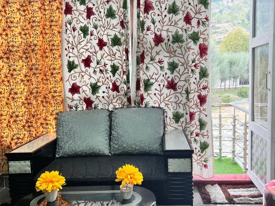 Seating area by the garden window in a Deluxe Room at Hotel Seven Pahalgam