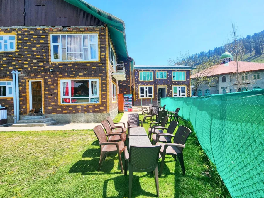 Exterior of Hotel Seven Pahalgam with garden chairs on the lawn