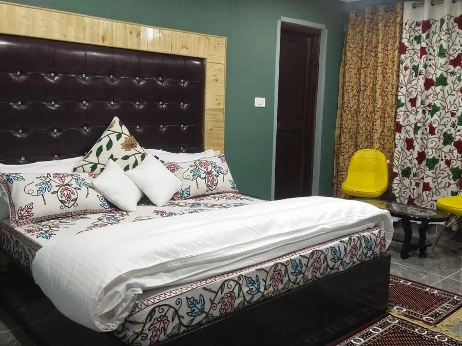 Guest room at Hotel Seven Pahalgam with two chairs by the window